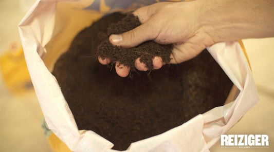 A person's hand holding soil