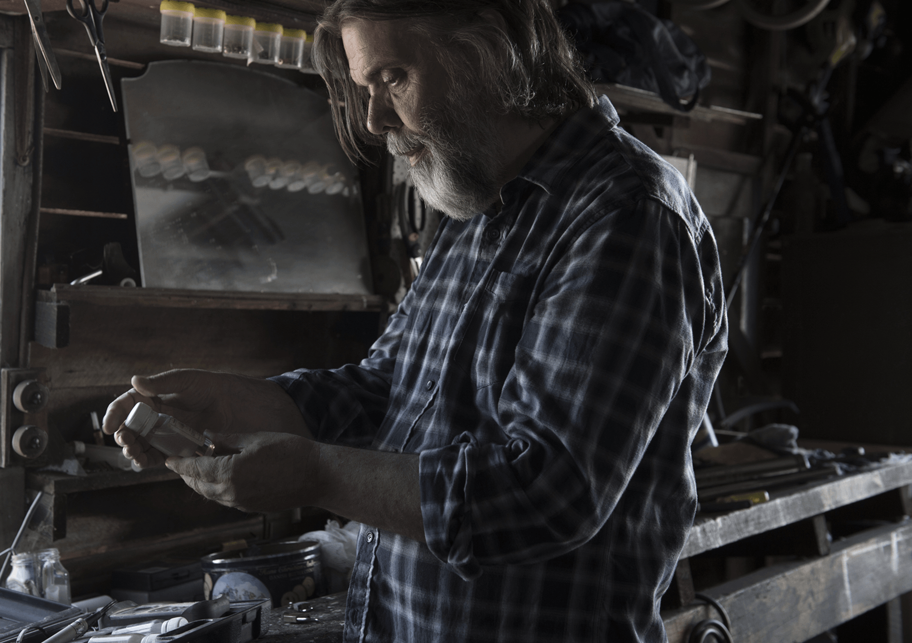 Man in workshop holding a bottle of liquid